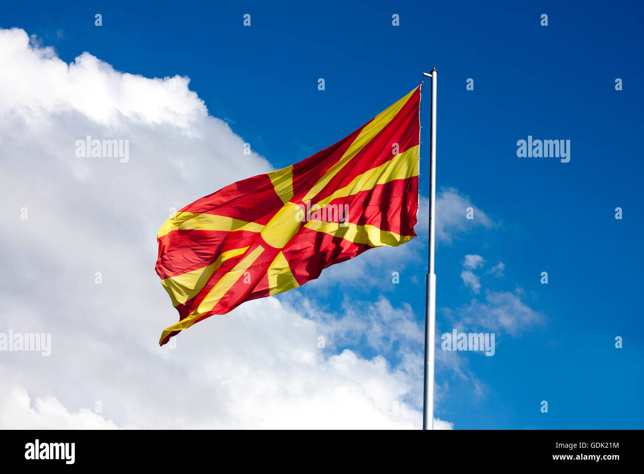 Bandiera macedone sventolare sul bianco e blu cielo, sul montante. Giornata di sole. Foto Stock