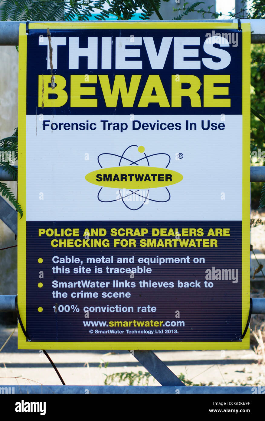 Regno Unito. Un segnale di avvertimento su un sito industriale affermando che SmartWater è in uso un liquido sistema di marcatura sensibile alla luce UV Foto Stock