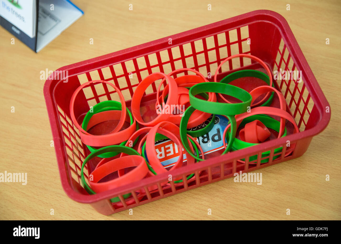 Una scatola di braccialetti colorati in un Regno Unito la scuola primaria Foto Stock