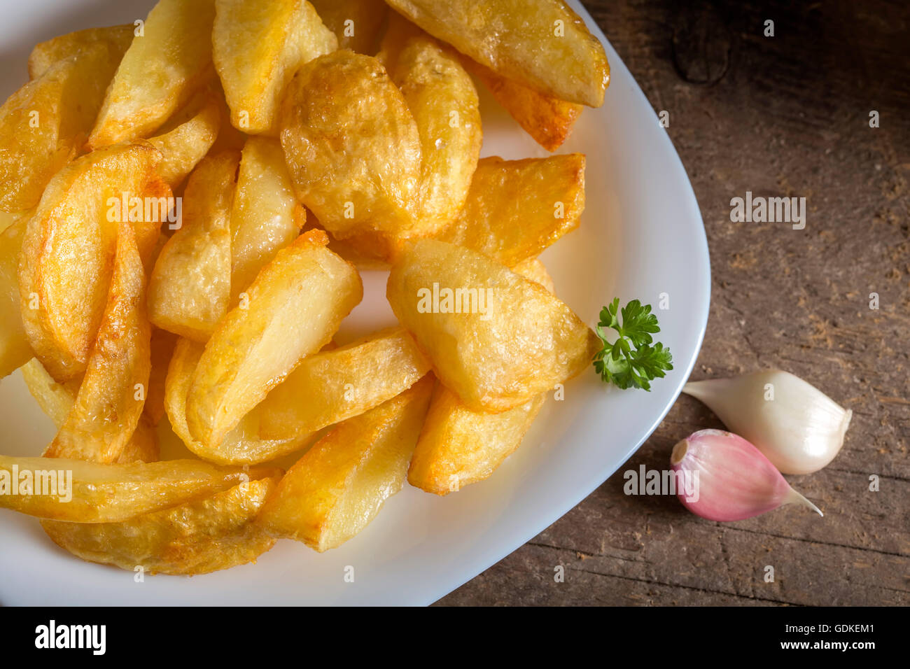 Porzione di le patate fritte fatte in casa (patate) sulla piastra bianca e legno sfondo rustico Foto Stock