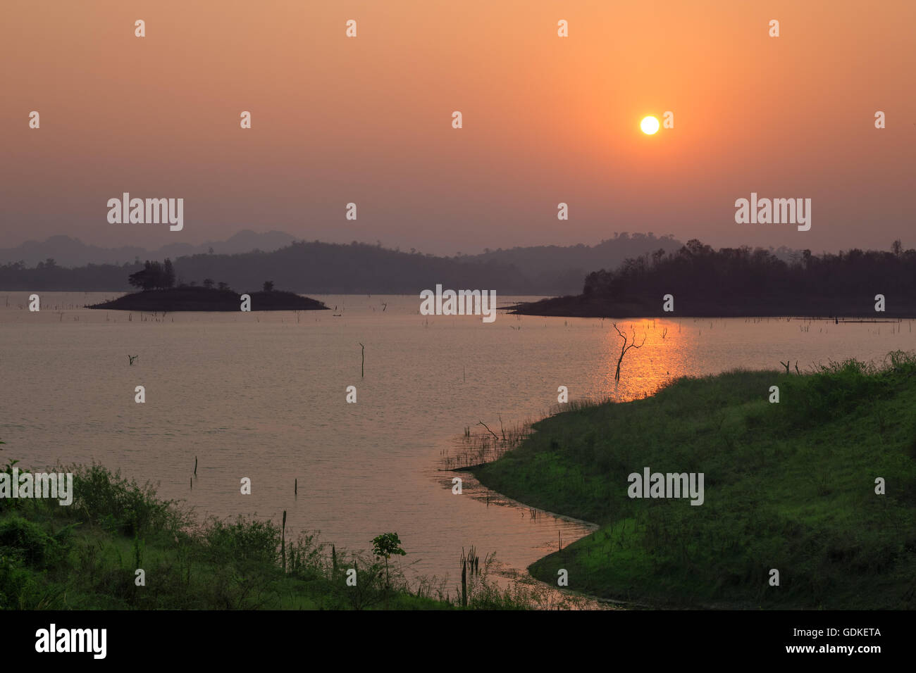 Tramonto sul lago con una bella luce arancione. Pompeo, Kanchanaburi, Thailandia. Foto Stock