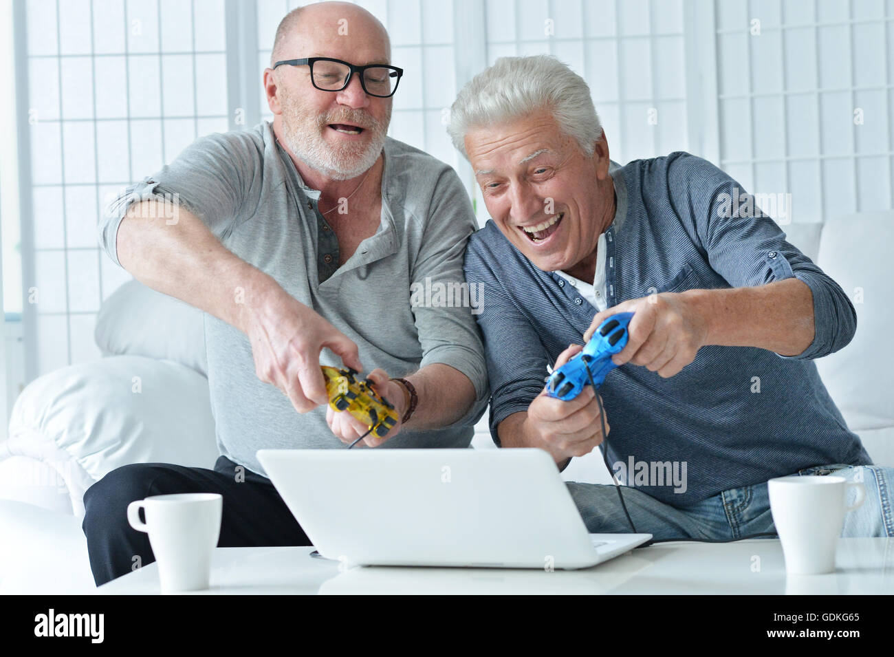 Due alti uomini giocando su laptop Foto Stock