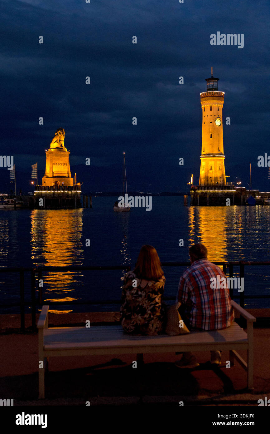 Statua di Lion e il faro di sera, Lindau, Lago di Costanza, Baviera, Germania Foto Stock