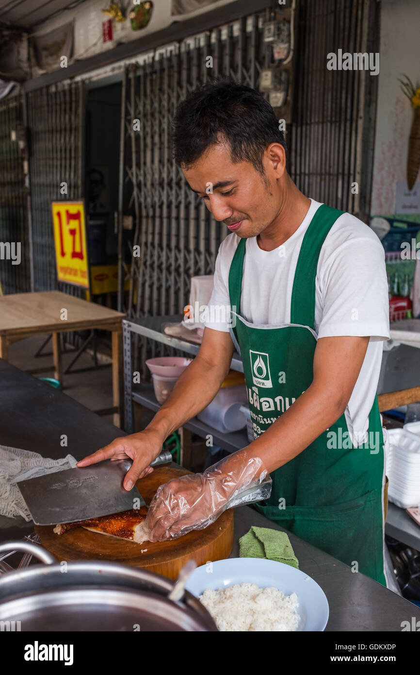 Chef per affettare anatra arrosto con cleaver sul tagliere di legno, Chiang Mai Thailandia Foto Stock