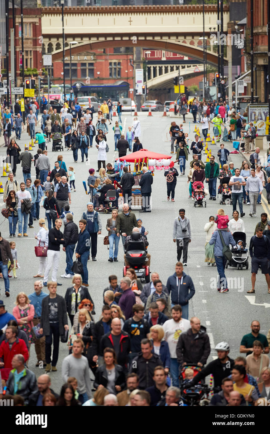 Deansgate Manchester la strada principale che attraversa il centro città nord area di magazzino parte del distretto sezione insegne dei negozi affollati occupato pers Foto Stock