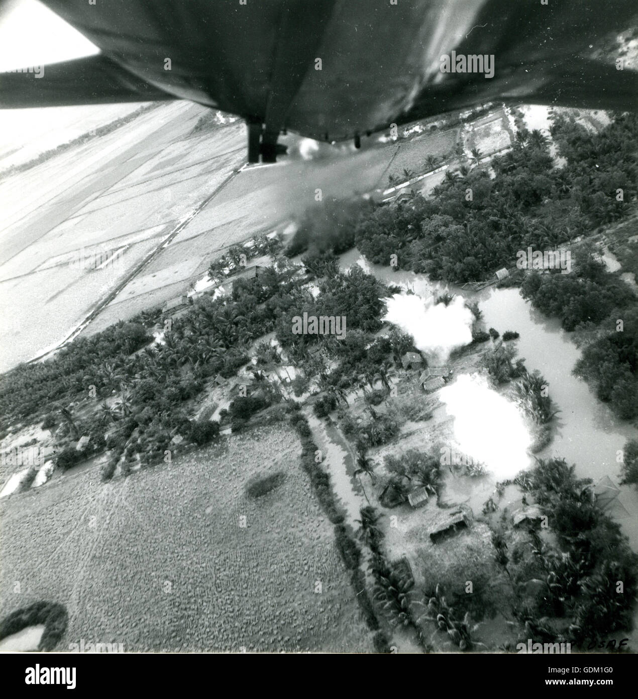 Fire-bombardamento di un sospetto Viet Cong villaggio da un USAF F-100D nel Vietnam del Sud. Foto Stock