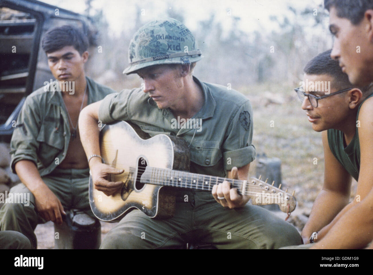 Dopo una dura giornata, a pochi membri della società A, 3 miliardi, XXII Inf (MECHANIZED), XXV Inf.Div, si radunano suona la chitarra e cantare un paio di canzoni. Foto Stock