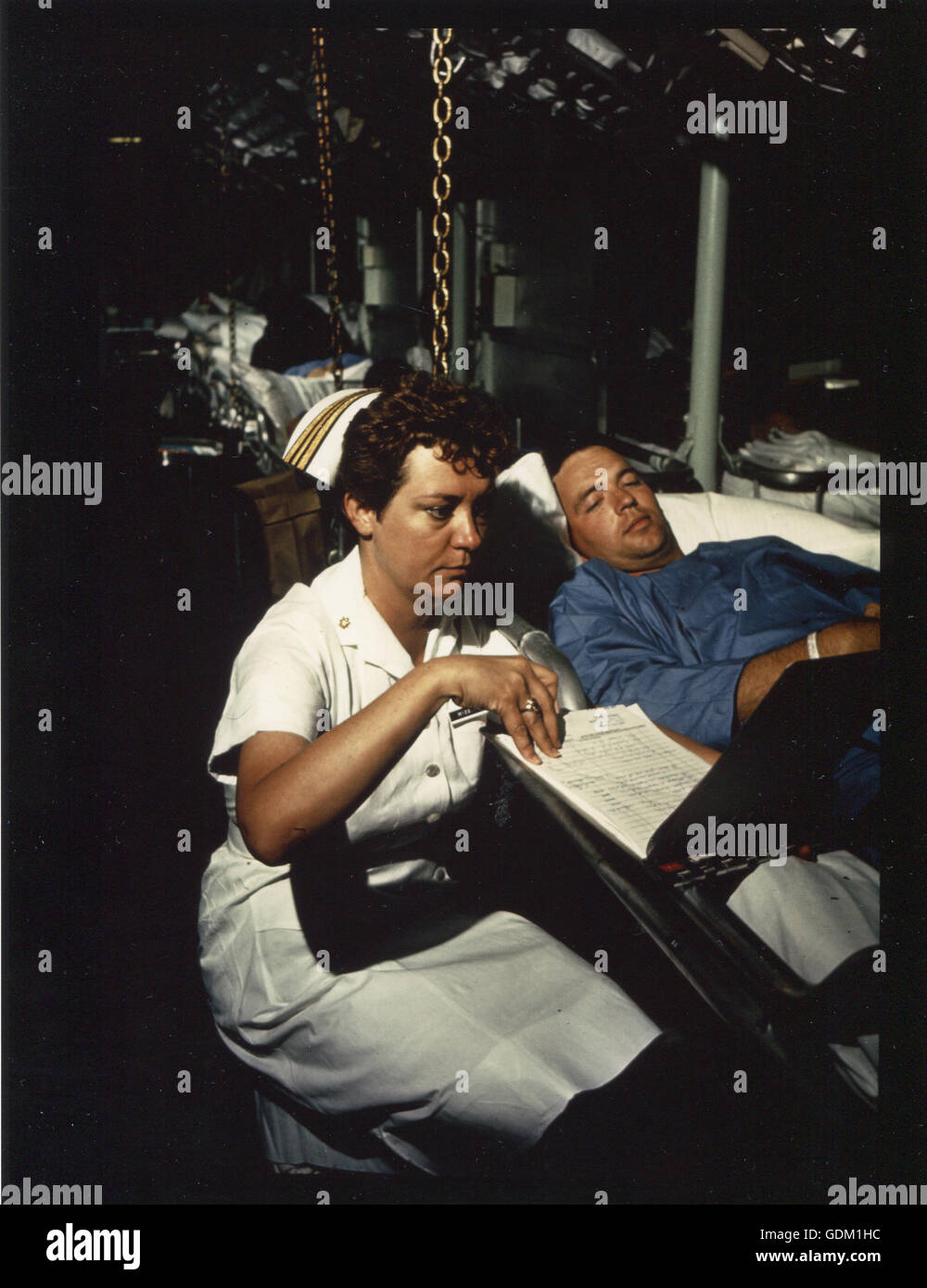 Navy Nurse Lt. Il comandante Dorothy Ryan controlla il grafico di medici di Marine Cpl. Roy Hadaway a bordo della nave ospedale USS riposo off Vietnam del Sud. Miss Ryan è uno dei 29 infermieri a bordo della nave. Foto Stock