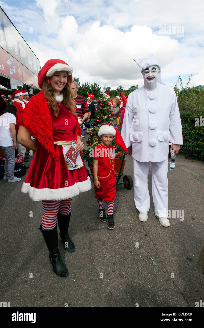 Copenhagen, Danimarca - 18 Luglio 2016: Santa Claus' partecipanti al Mondiale di Santa Claus Congress 2016 visite al porto promenade, Langelinie, dove la scultura, La Sirenetta è disposto e mani Mani dolci per i bambini. Essi avevano anche alcune gravi colloqui per i bambini circa il prossimo Natale e desidera elenco. Al photo Bakken, iconici Pjerrot (R) il clown assiste alla gita. Il congresso ha avuto luogo dal 1957. Il luogo e l organizzatore è Bakken,, il mondo il più antico parco di divertimenti e si trova a nord di Copenhagen. Credito: OJPHOTOS/Alamy Live News Foto Stock