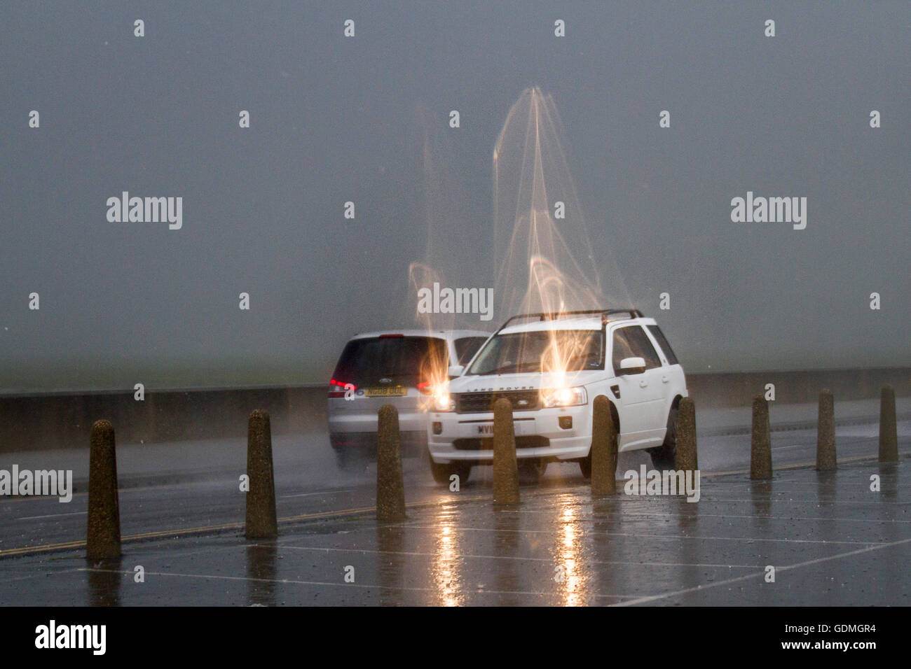 Southport Merseyside, Regno Unito. Il 20 luglio, 2016. Heavy Rain, thundery docce e cieli bui oltre la strada costiera come pendolari negoziare allagato strade e sopportare grandine sul lungomare esplanade. Forti piogge e inondazioni che causano un eccessivo spray che colpisce la visibilità. Credito: MediaWorldImages/Alamy Live News Foto Stock