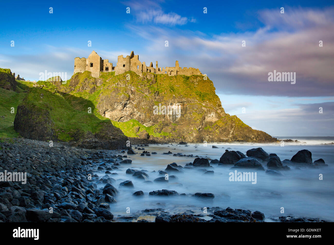 Sunrise over Dunluce Castle lungo la costa settentrionale della contea di Antrim, Irlanda del Nord, Regno Unito Foto Stock