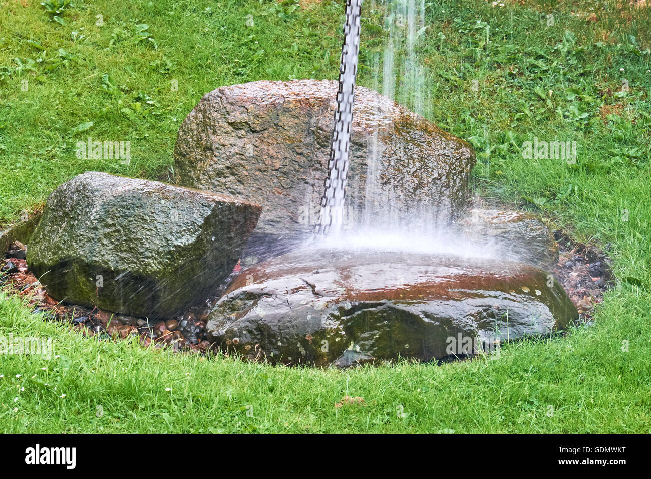 Grandi quantità di acqua che scorre verso il basso di una catena di anelli metallici di atterraggio su grossi massi di granito a causa delle pesanti piogge Foto Stock