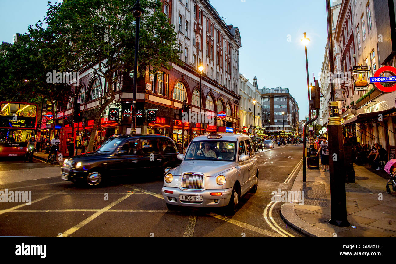 Taxi neri nel West End di Londra di notte Londra REGNO UNITO Foto Stock