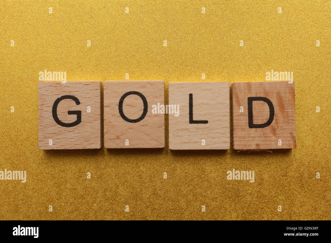 Lettere di legno ortografia oro su sfondo giallo Foto Stock
