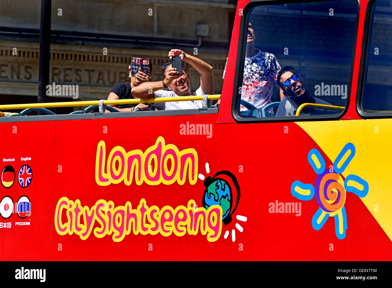 Londra, Inghilterra, Regno Unito. I turisti al piano superiore di un open top bus panoramico Foto Stock