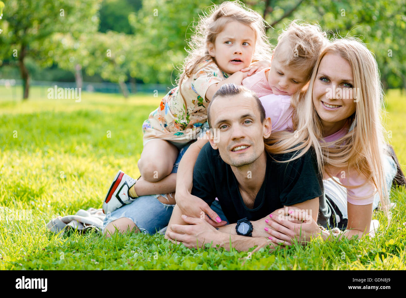 Famiglia giovane giacente su erba in campagna Foto Stock