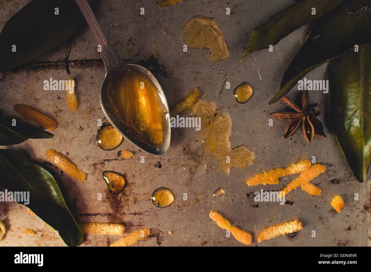 Orange inceppamento in un cucchiaio su un tavolo di ferro con anice stellato e orange leafs Foto Stock