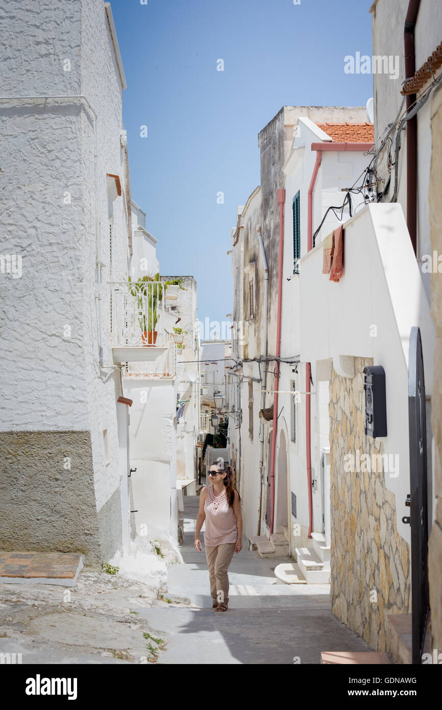 Giovane turista passeggiando per le strade assolate di Vieste, Italia Foto Stock