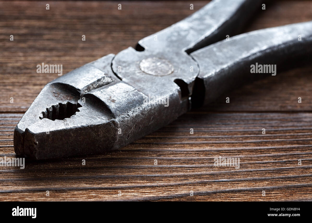 Vecchio arrugginito pinze su sfondo di legno Foto Stock