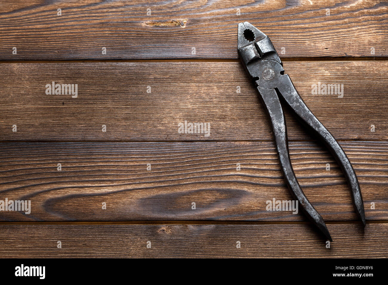 Vecchio arrugginito pinze su sfondo di legno Foto Stock