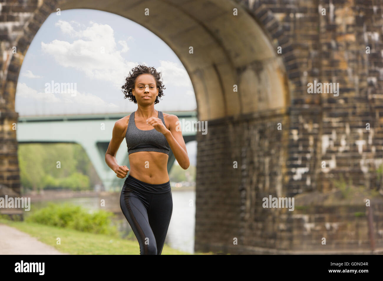 Donna che indossa spandex jogging da bridge Foto Stock