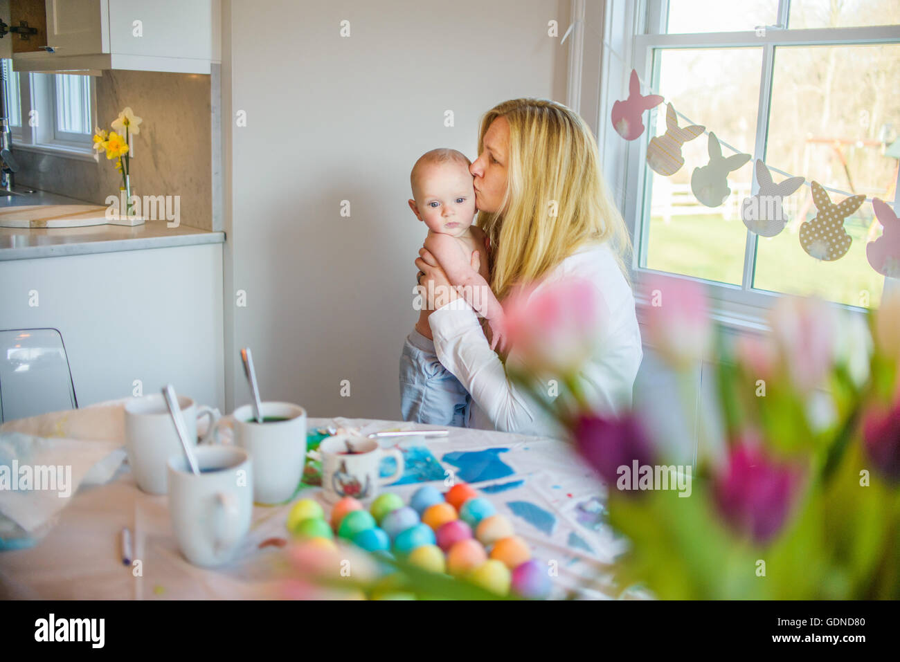 Madre al tavolo da pranzo kissing figlio sul fronte Foto Stock