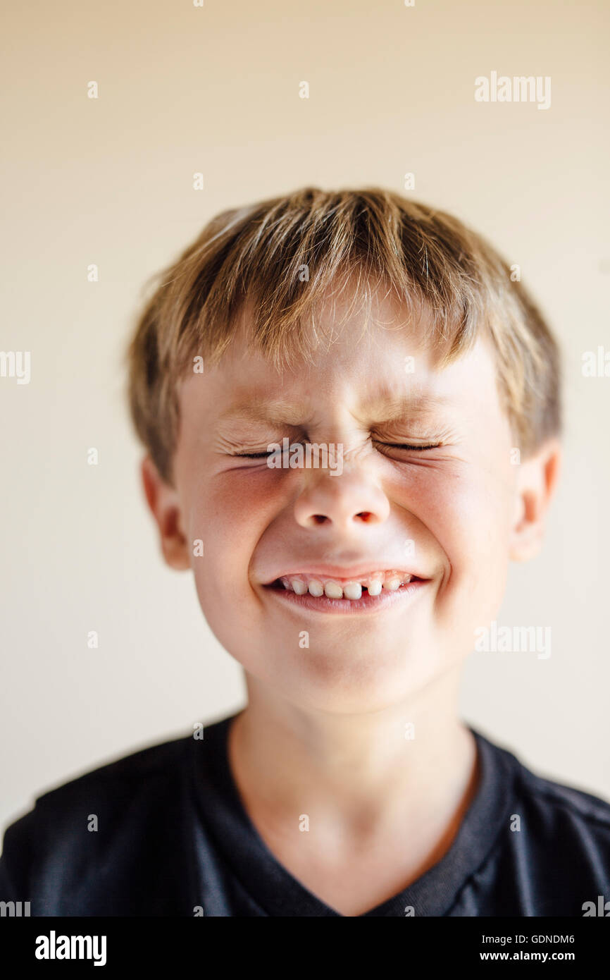 Ritratto in studio del ragazzo con gli occhi chiusi e sorriso toothy Foto Stock