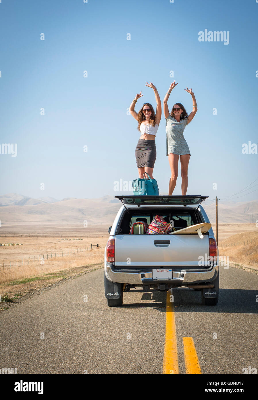 Le donne in piedi sul tetto del veicolo, Highway 1, CALIFORNIA, STATI UNITI D'AMERICA Foto Stock