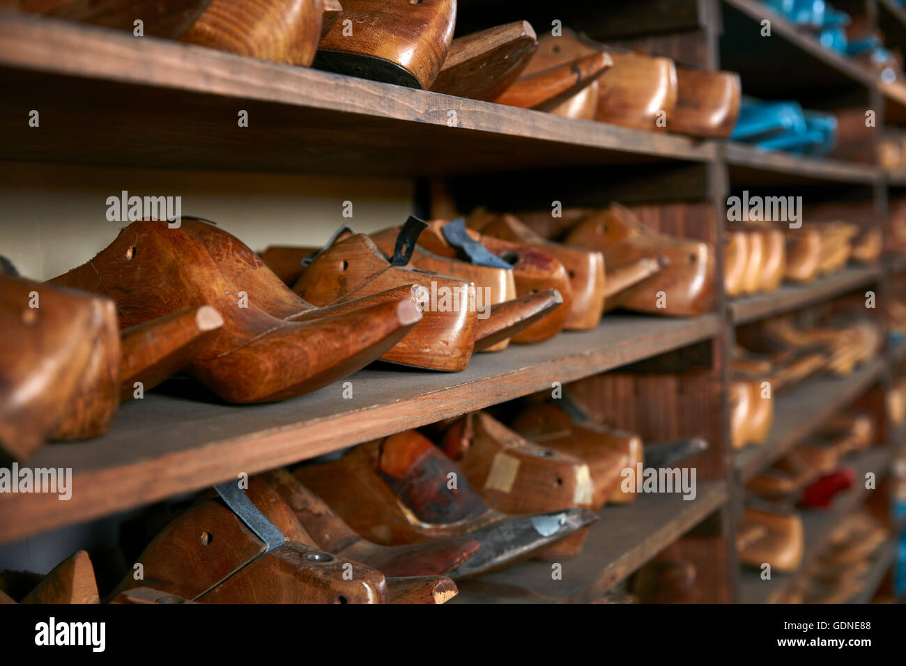 Righe della vecchia scarpa in legno dura su scaffali in tradizionale negozio di calzature, il fuoco selettivo Foto Stock