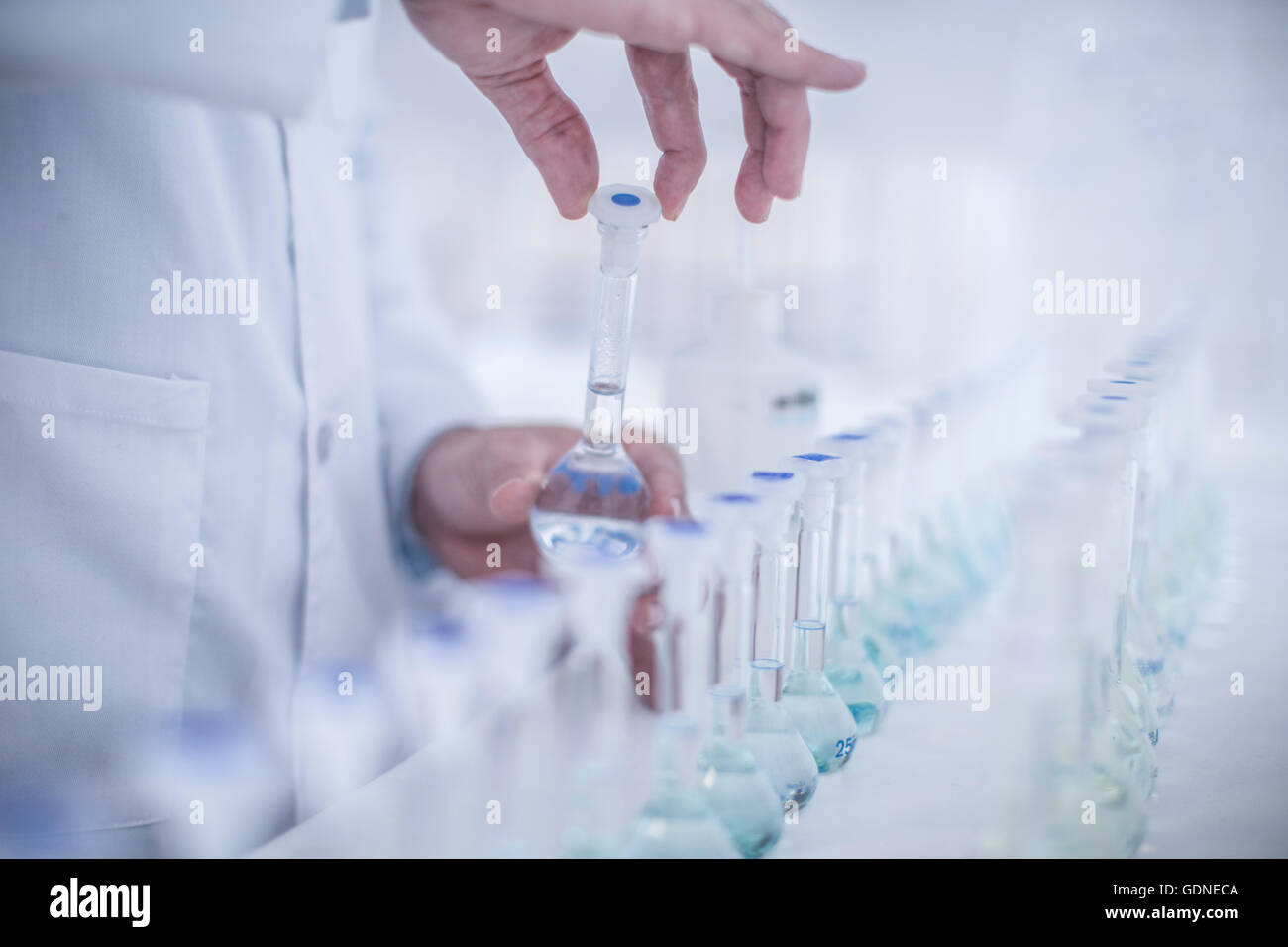 Uomo in laboratorio, coperchio di serraggio sul tubo di prova, close-up Foto Stock