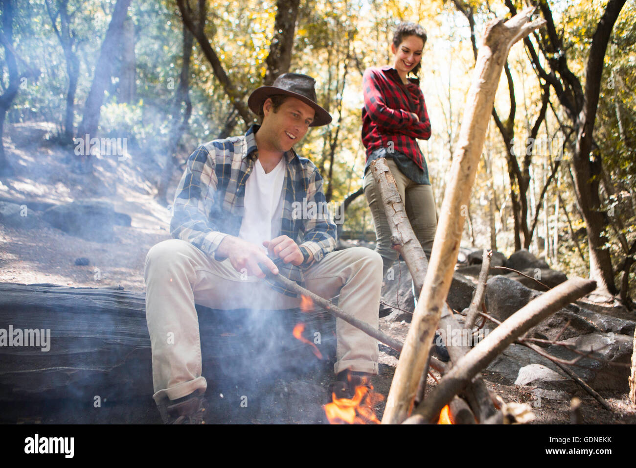 Giovane maschio e femmina escursionisti tendendo il fuoco nella foresta, Arcadia, California, Stati Uniti d'America Foto Stock