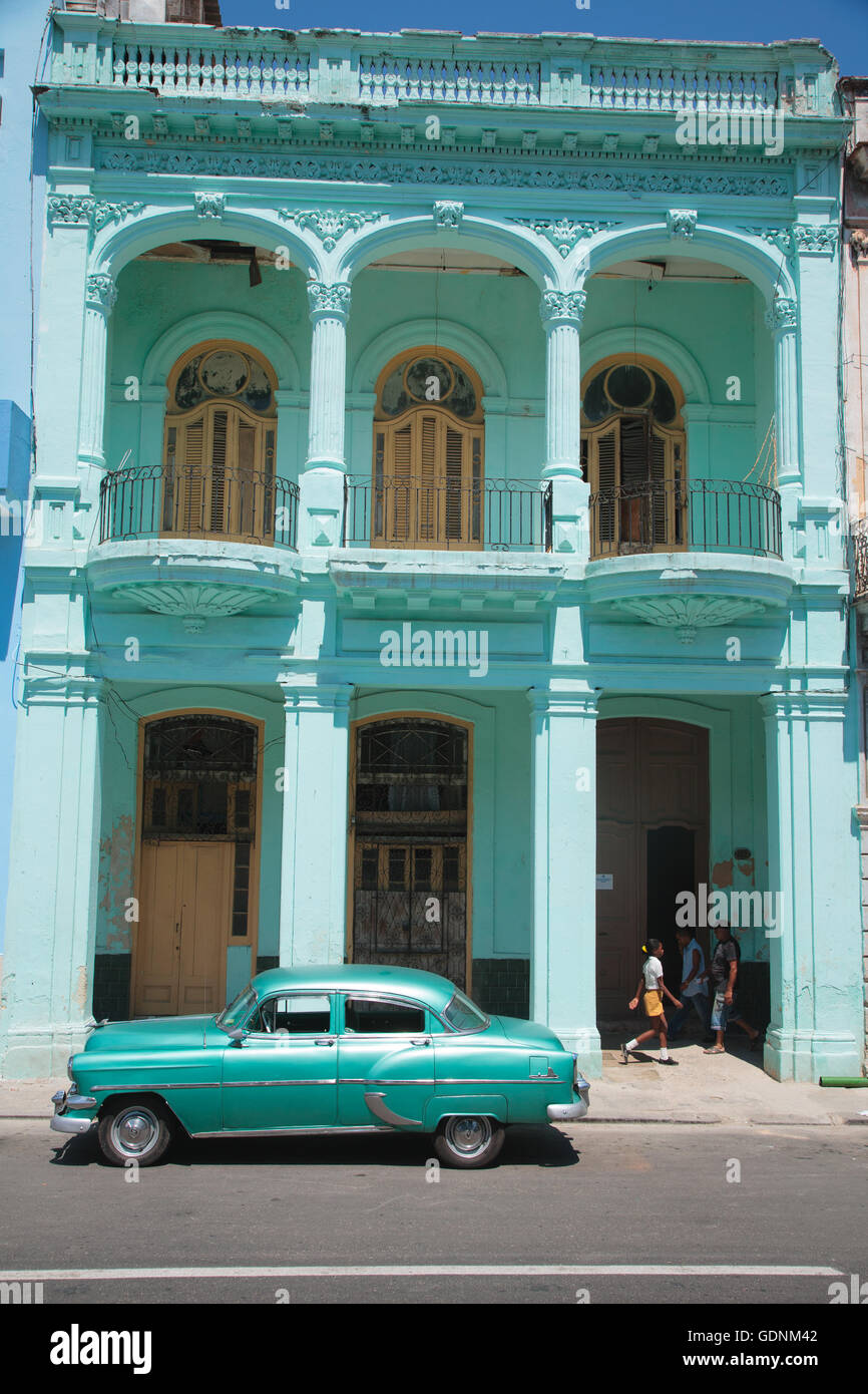 Green building e la classica degli anni cinquanta auto sul Paseo de Marti, Habana Vieja, Havana, Cuba Foto Stock