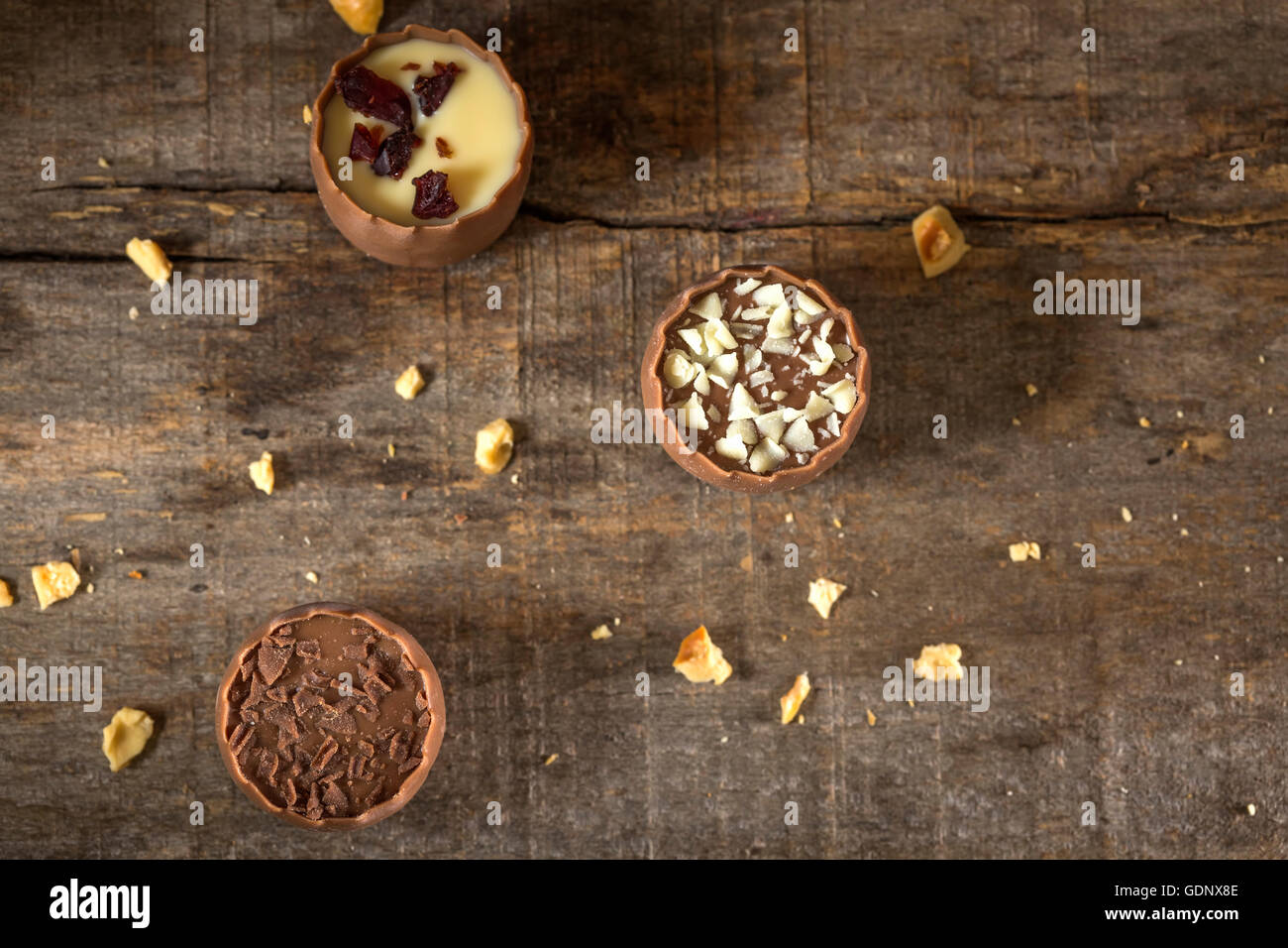 Tre cioccolatini su uno sfondo di legno Foto Stock