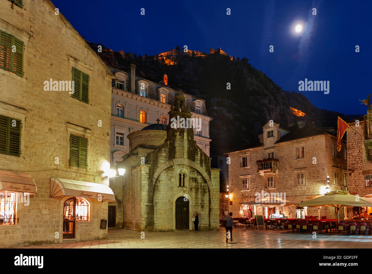 San Luca la Chiesa in piazza (Trg Sv Luca) e fortificazioni della città di cui sopra su una serata al chiaro di luna: Kotor, Montenegro Foto Stock