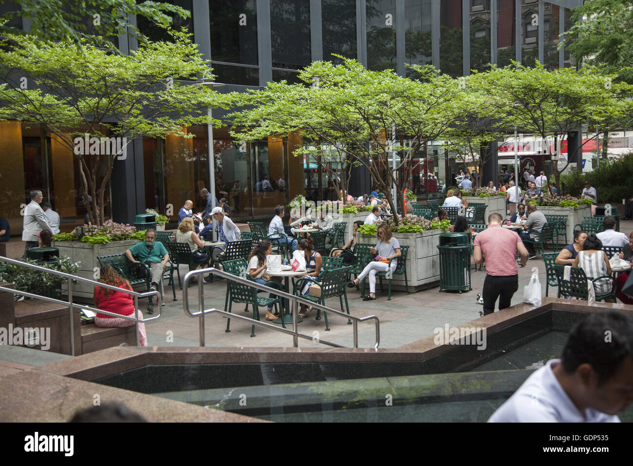 Le persone a rilassarsi nel mandato di spazi pubblici tra grandi edifici aziendali in midtown Manhattan. Foto Stock