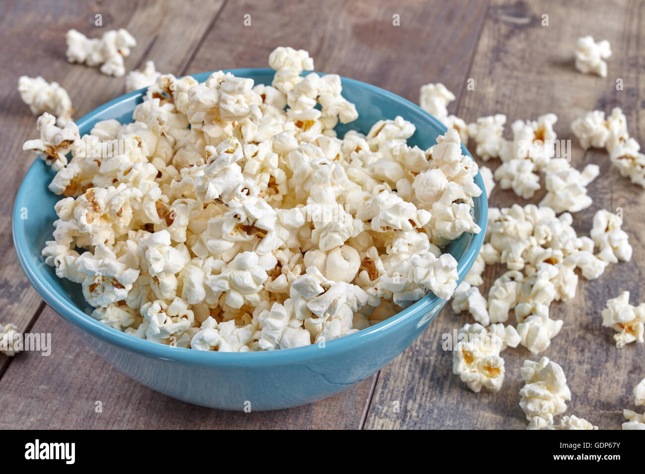 Vaso blu con popcorn su sfondo di legno. Foto Stock