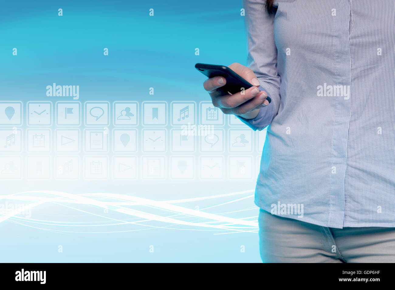 Giovane donna utilizzando il telefono cellulare e le icone digitali dietro di lei, metà sezione Foto Stock