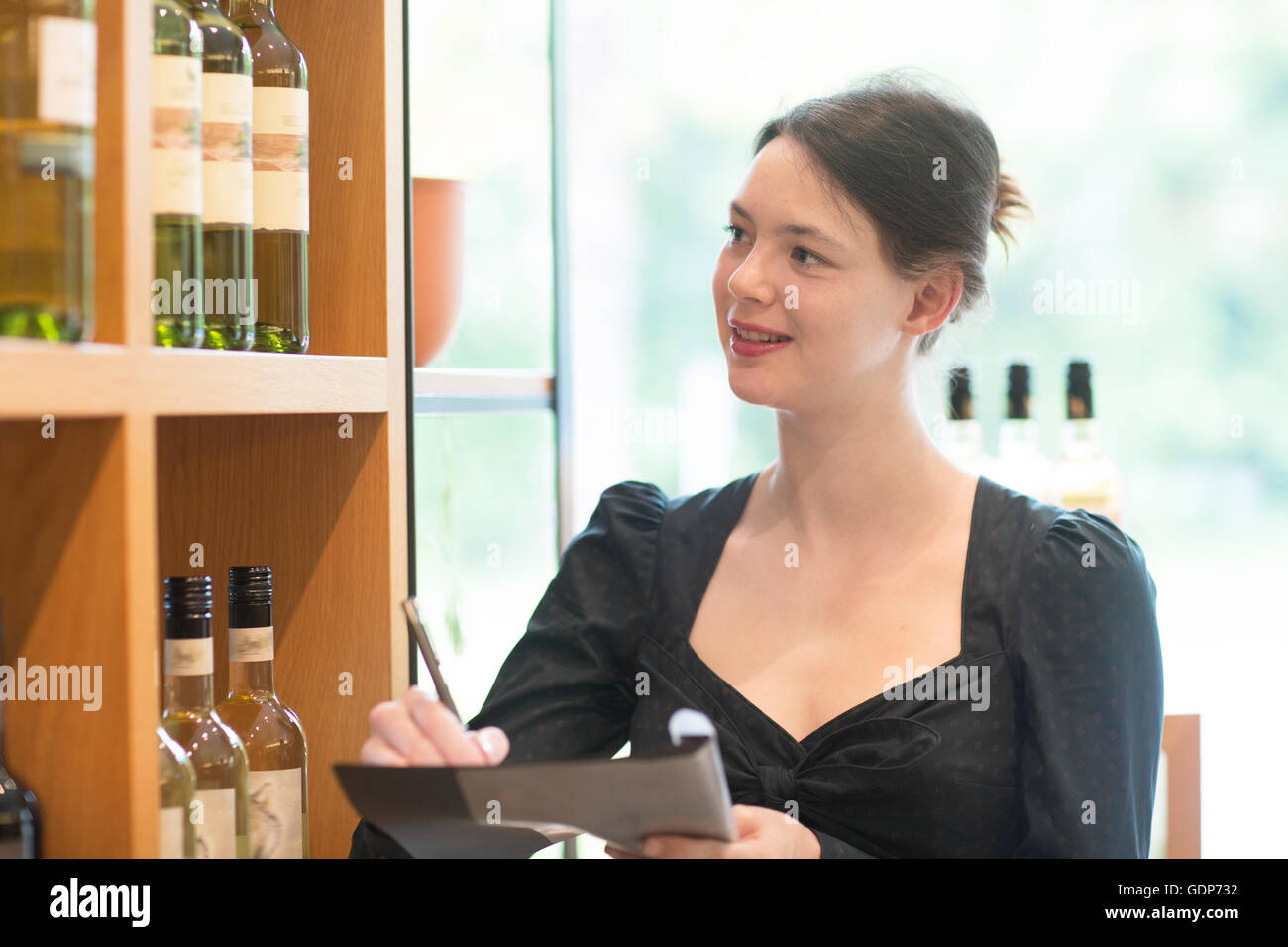 Assistente di negozio in negozio del vino facendo di inventario Foto Stock
