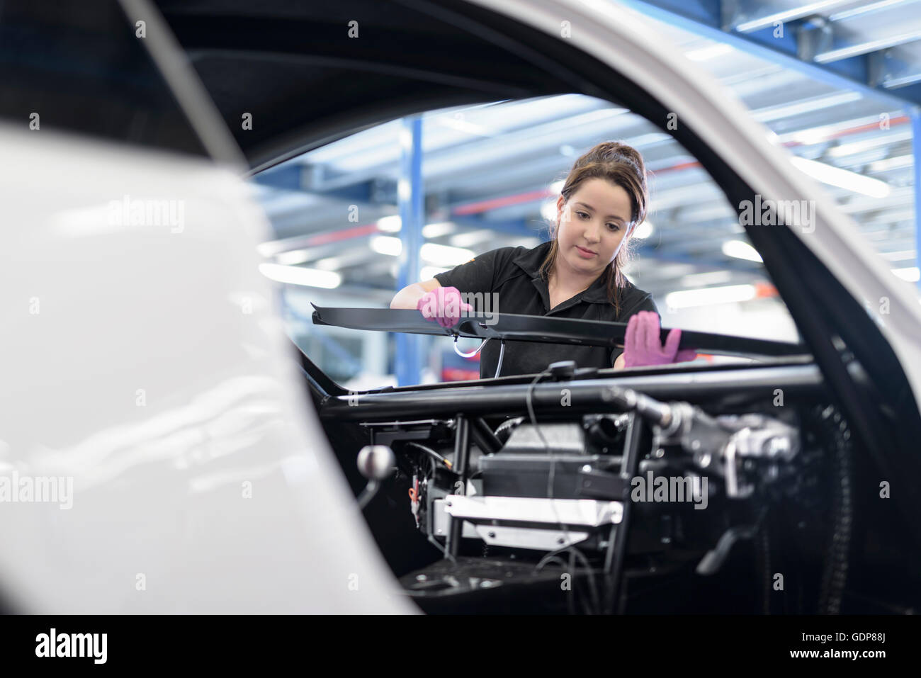 Ingegnere femmina assembla auto in auto racing factory Foto Stock