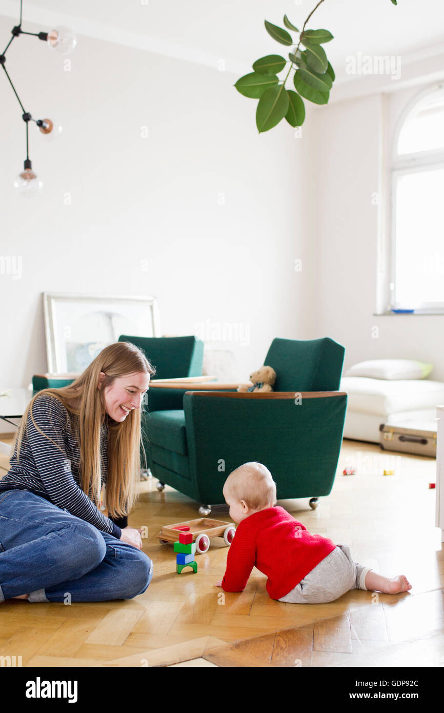 Metà donna adulta e bambina gioca con la costruzione di blocchi sul soggiorno piano Foto Stock