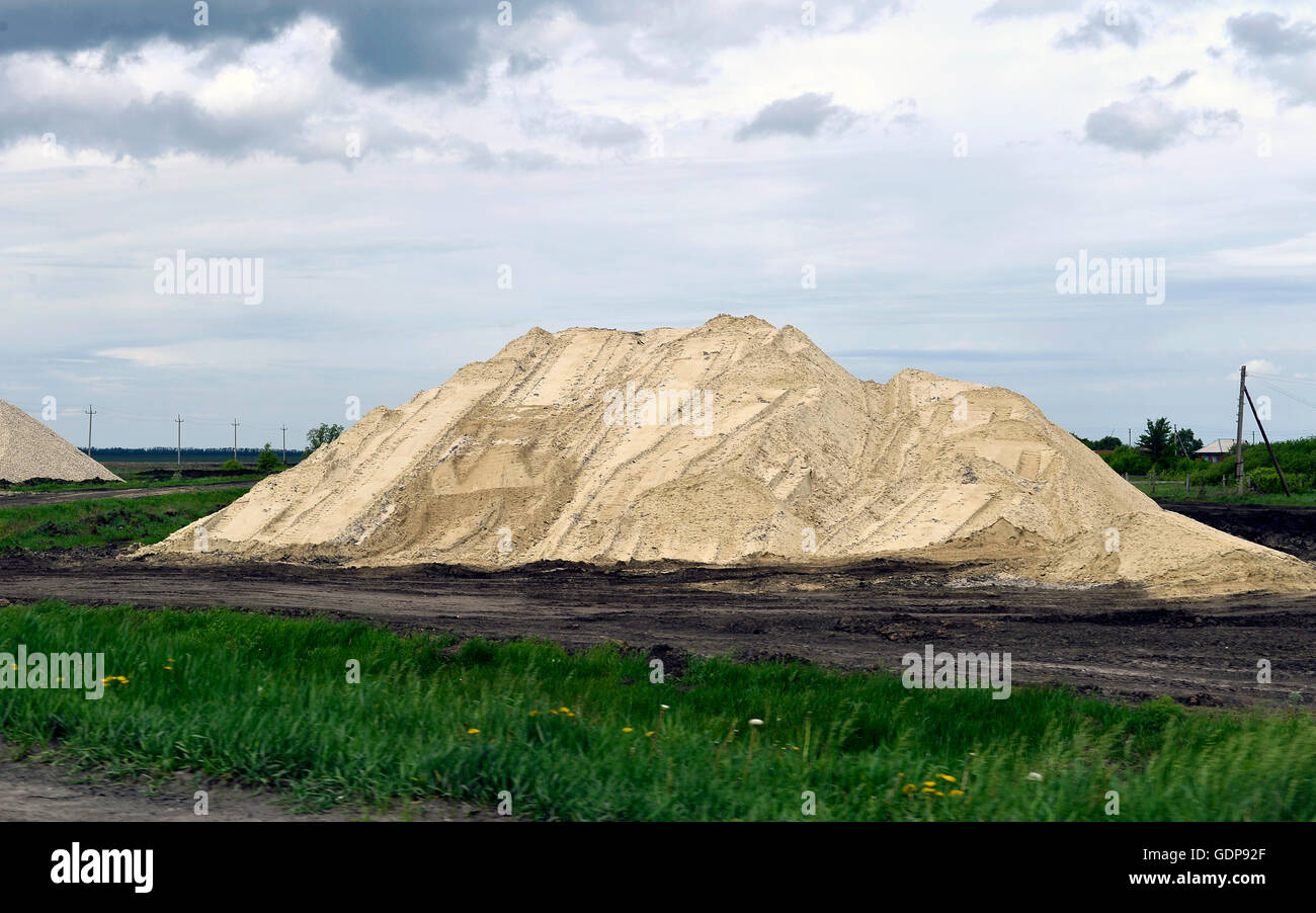 Escavatore giallo lavorando a scavare nella cava di sabbia Foto Stock