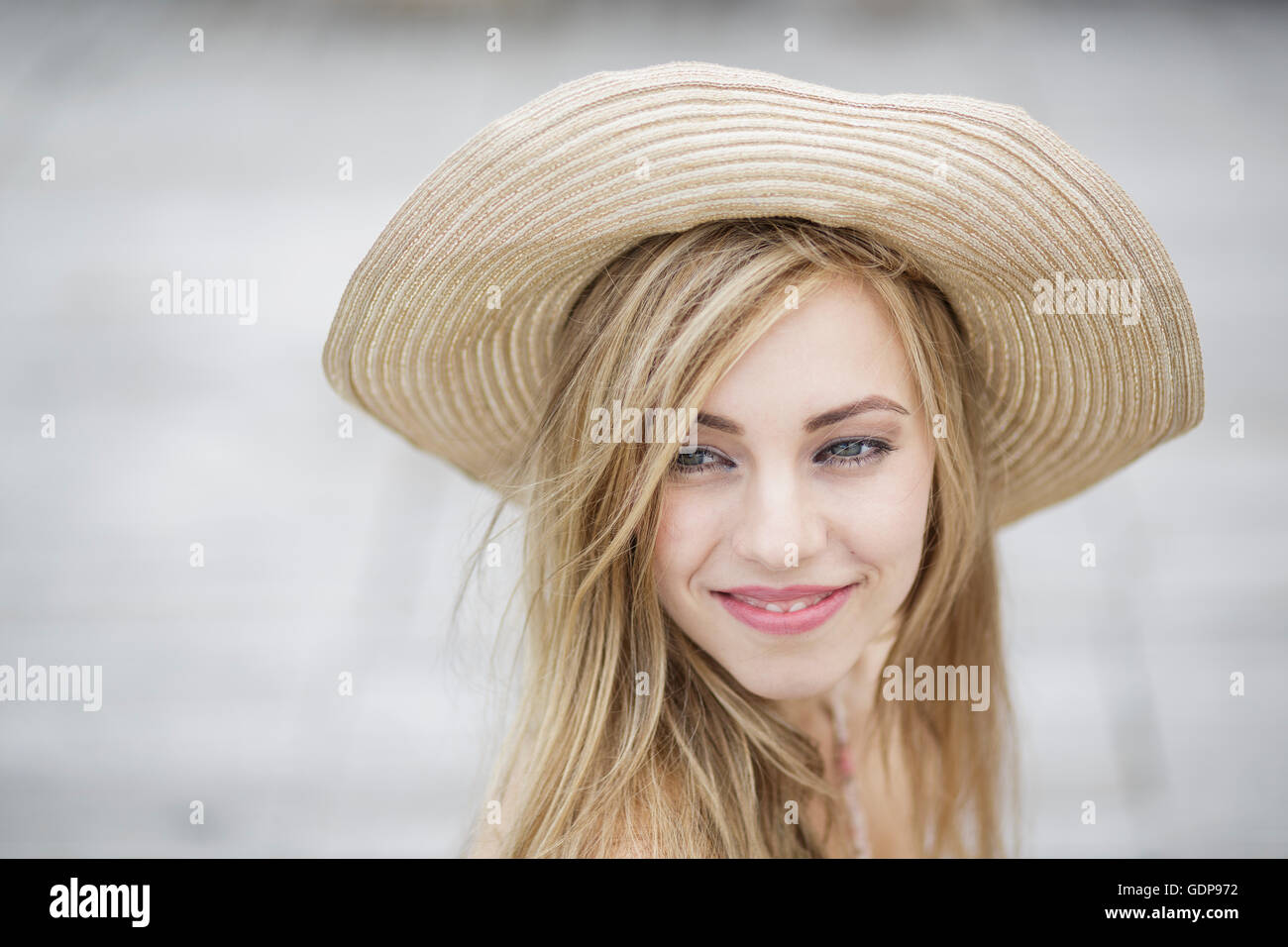 Ritratto di bellissimi capelli lunghi giovane donna indossa cappello di paglia in città Foto Stock