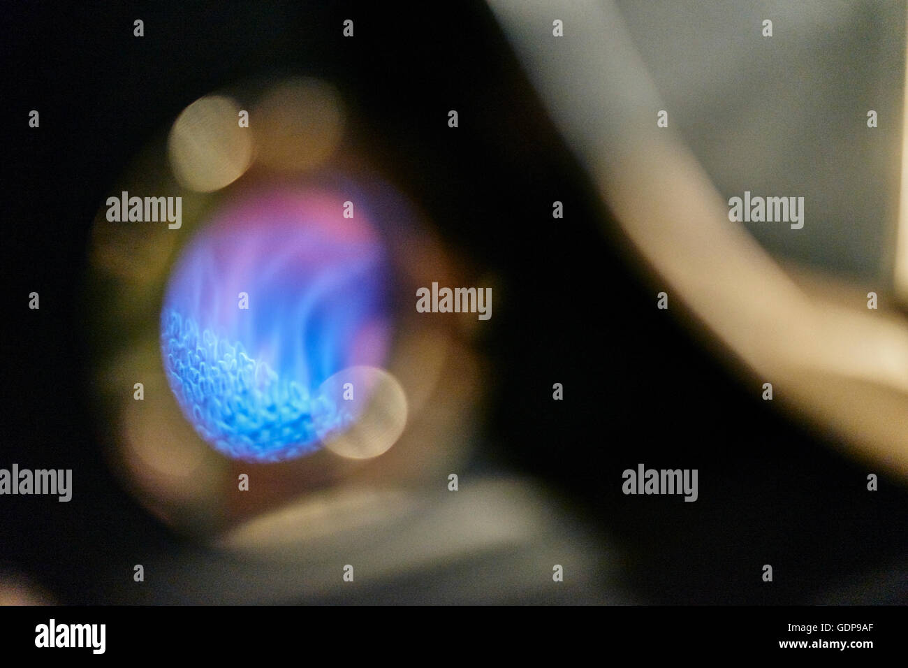 Messa a fuoco poco profonda close up blu fiamma a gas torrefazione di caffè nella caffetteria Foto Stock