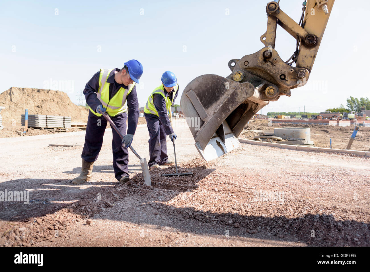 Apprendista costruttori strada di livellamento con la scavatrice sul sito di costruzione Foto Stock