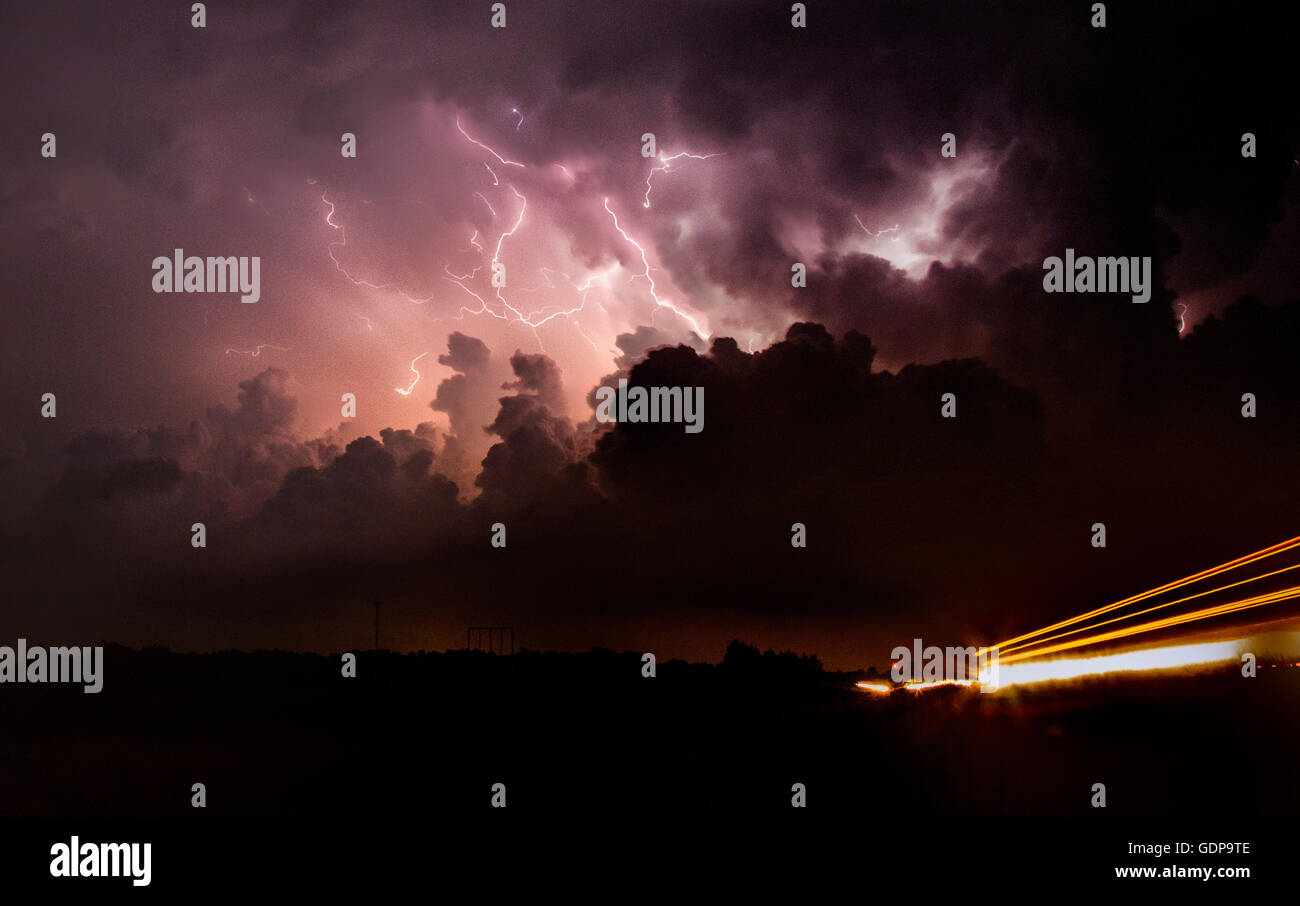 Il fulmine riprese la corrente ascensionale e l'incudine di tornadic supercell di notte con auto sentieri di luce Foto Stock
