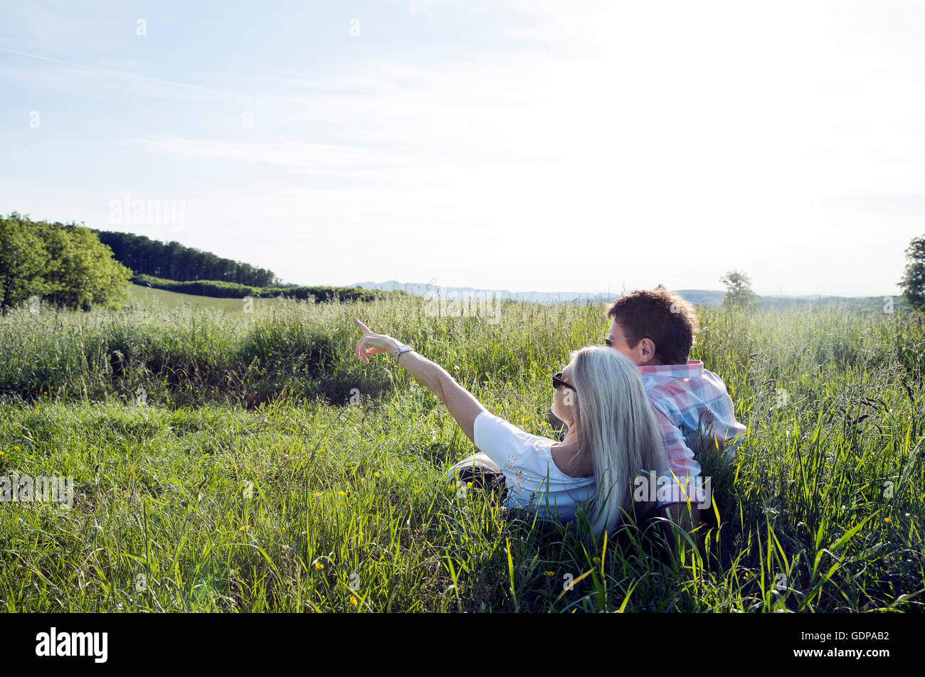 Coppia matura che giace nel campo Foto Stock