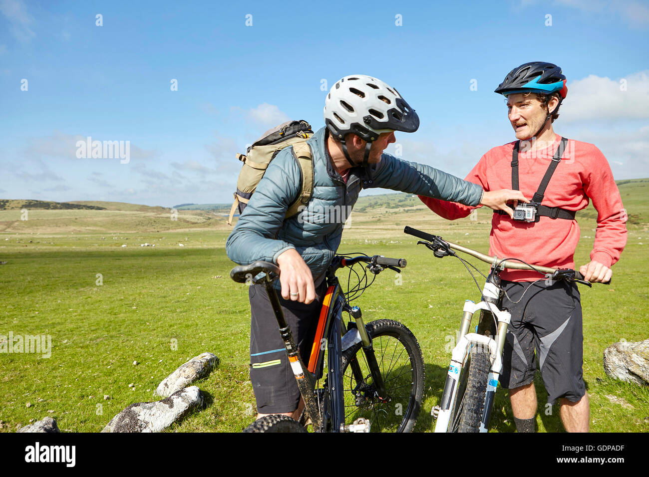 I ciclisti sulla collina di azione di fissaggio telecamera ad un amico Foto Stock