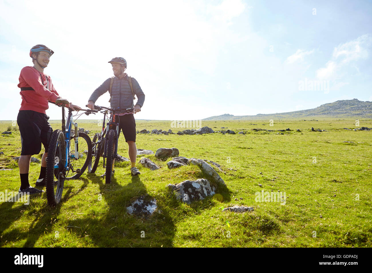 I ciclisti sulla collina tenendo le biciclette in chat Foto Stock