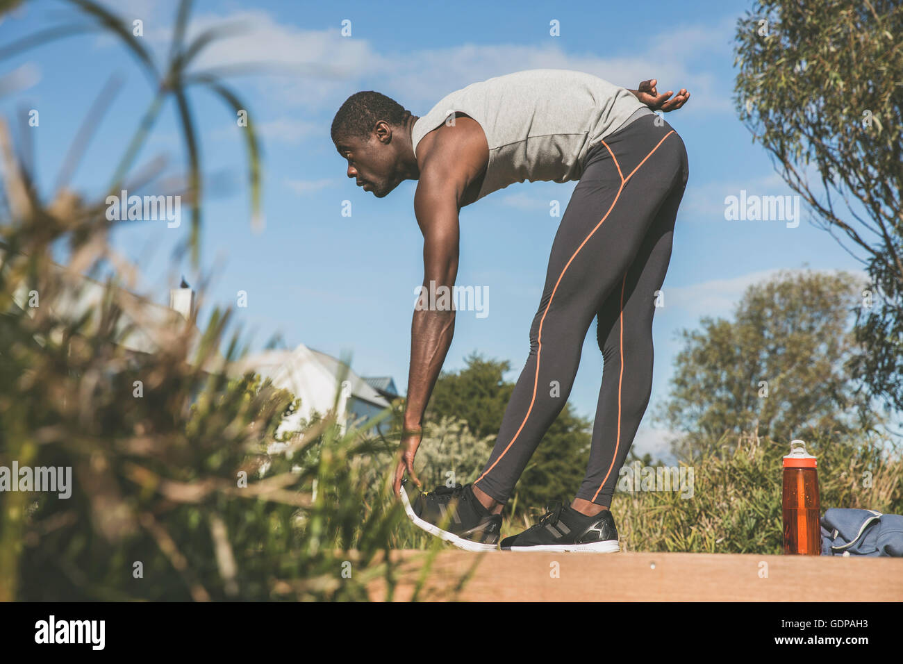 L'uomo flessione in avanti di toccare le dita dei piedi, stretching Foto Stock