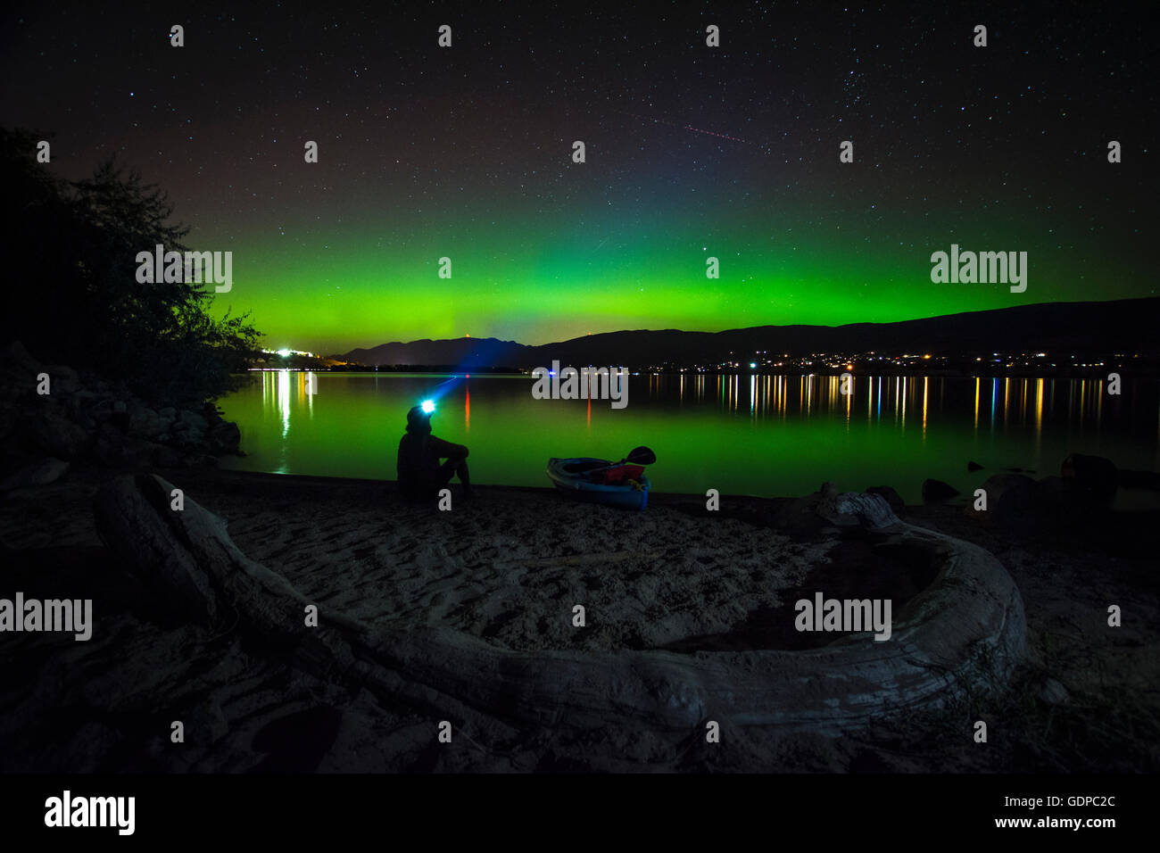 Uomo che guarda un aurora boreale oltre il Lago Okanagan, Kickininee Parco Provinciale, Penticton, British Columbia, Canada Foto Stock